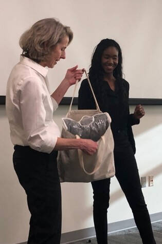 Dr Ellen Shupe giving gift bag to Justice Bolden